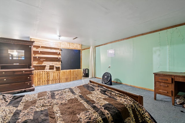 carpeted bedroom featuring wood walls