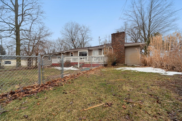 back of house with a yard, a chimney, fence, and a gate