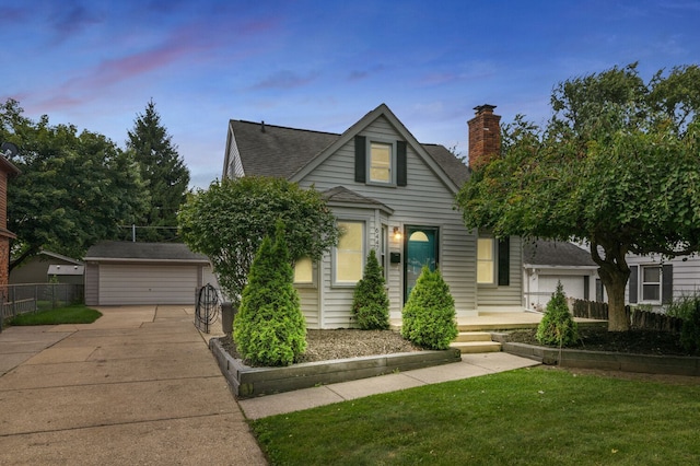 view of front facade with an outbuilding, a yard, a chimney, a detached garage, and fence