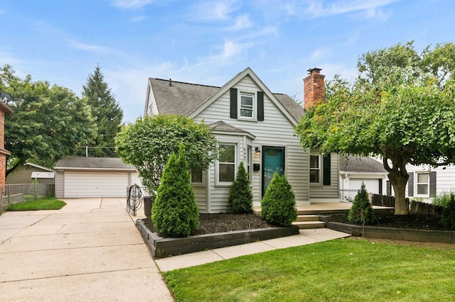 view of front of home featuring an outbuilding, a garage, fence, a chimney, and a front yard