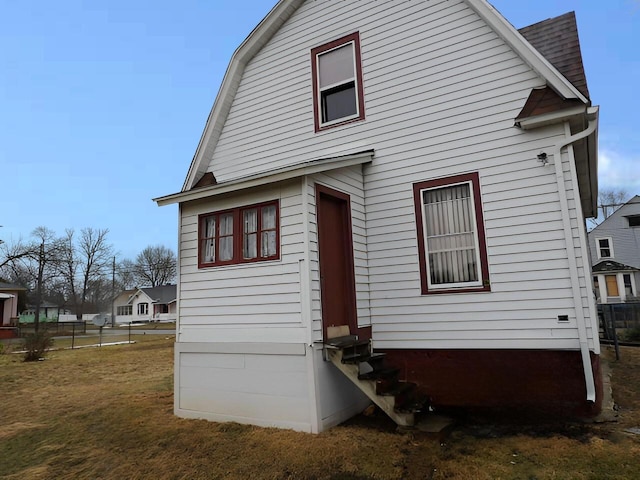 rear view of house featuring a yard and fence