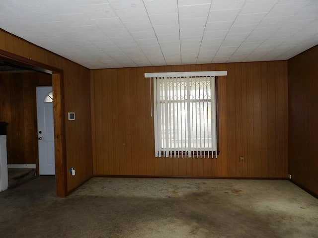 unfurnished room with wood walls