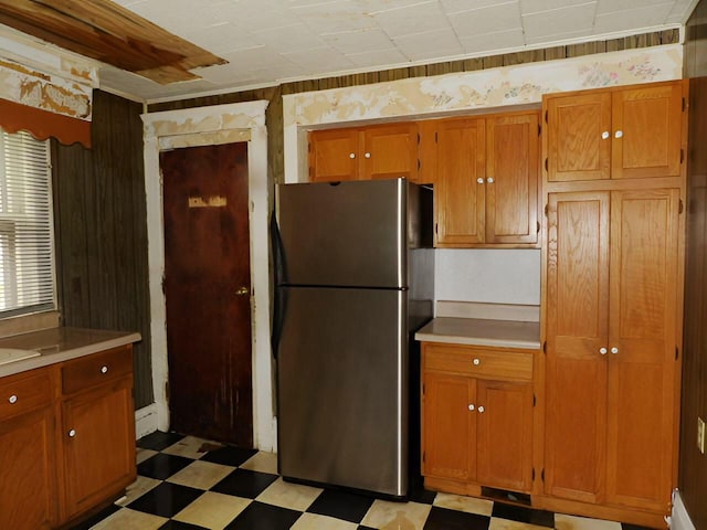 kitchen with light floors, brown cabinetry, light countertops, and freestanding refrigerator