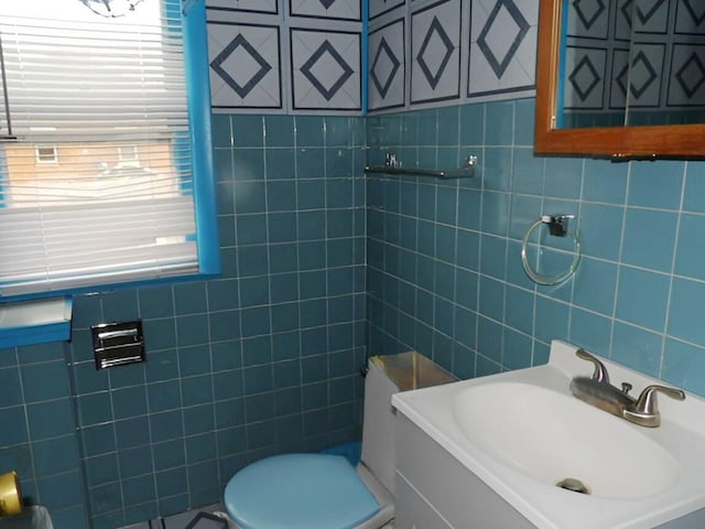 bathroom with a sink, tile walls, and toilet