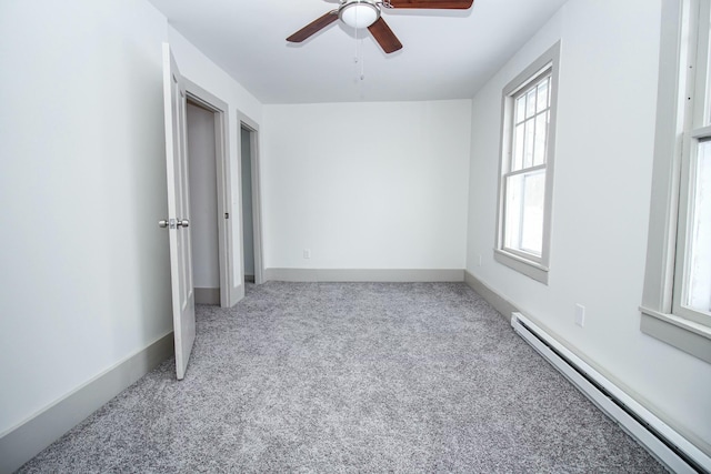 unfurnished bedroom featuring ceiling fan, carpet floors, baseboard heating, and baseboards