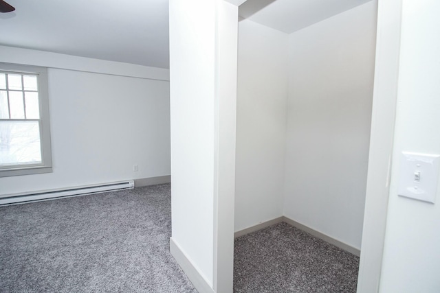 spare room featuring baseboard heating, carpet flooring, and baseboards