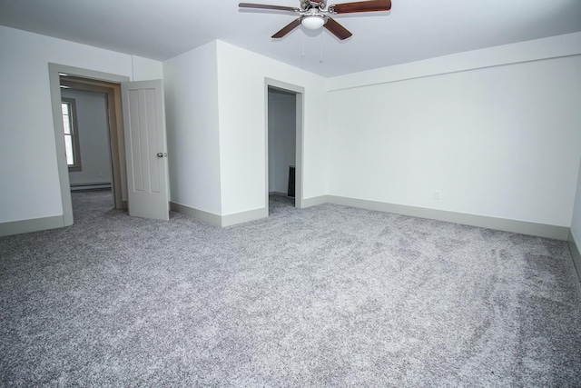 carpeted spare room with a baseboard heating unit, baseboards, and a ceiling fan