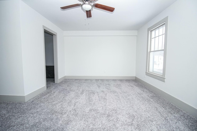 unfurnished room featuring carpet floors, ceiling fan, and baseboards