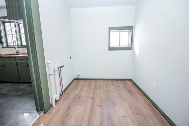 laundry room with laundry area, wood finished floors, hookup for a washing machine, hookup for an electric dryer, and a sink