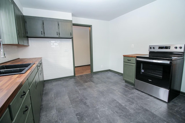 kitchen with electric range, wood counters, backsplash, and a sink