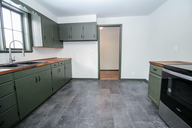 kitchen with green cabinets, butcher block counters, stainless steel electric range, and a sink