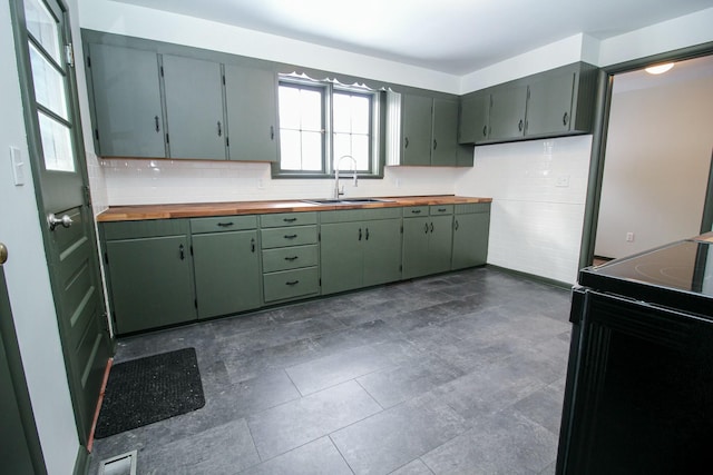 kitchen with black range with electric cooktop, butcher block counters, a sink, visible vents, and backsplash