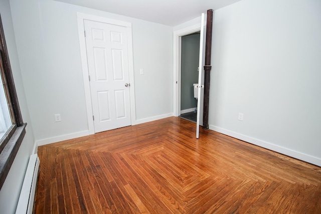 unfurnished bedroom featuring baseboards and baseboard heating