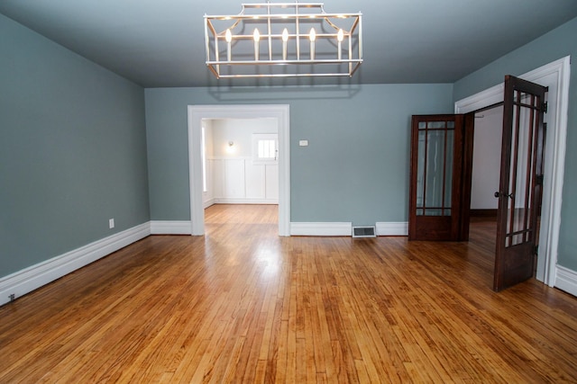 unfurnished room featuring wood-type flooring and baseboards