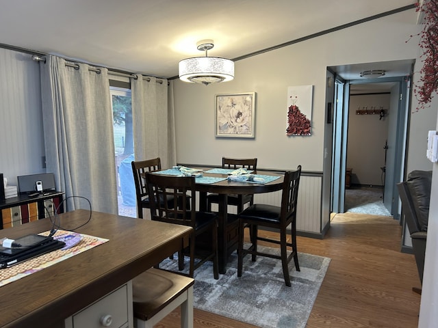 dining room with a wainscoted wall and wood finished floors