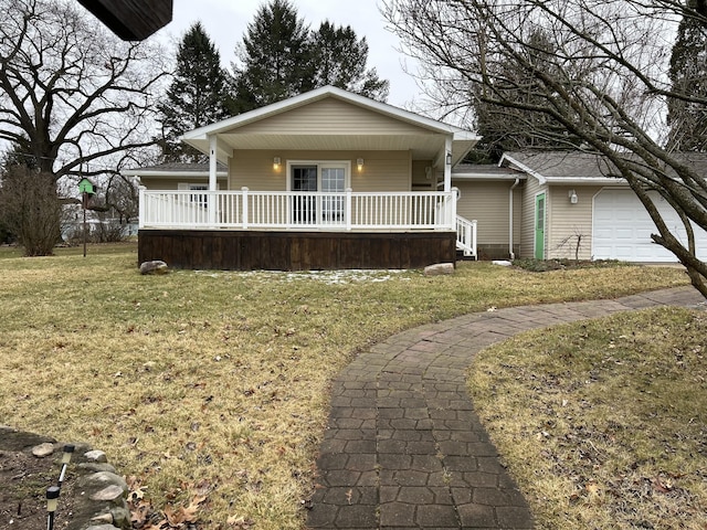 view of front of house featuring a garage, covered porch, and a front yard