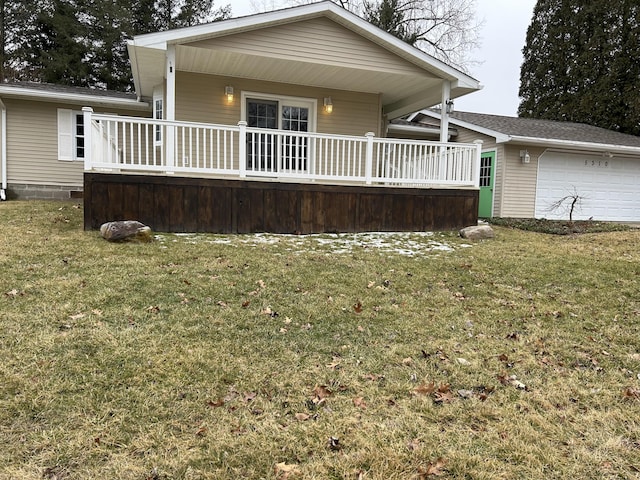 rear view of house with covered porch, a yard, and an attached garage