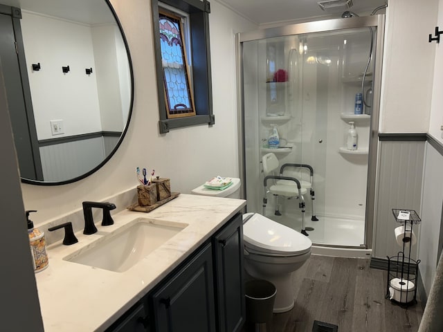 bathroom with visible vents, toilet, wood finished floors, vanity, and a shower stall