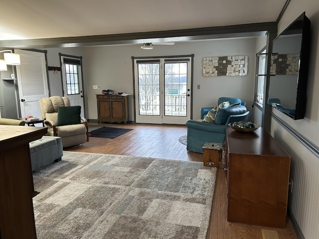 living area featuring ornamental molding, wood finished floors, and visible vents