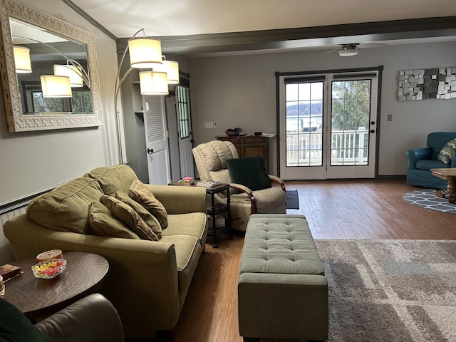 living area featuring ceiling fan, wood finished floors, and crown molding