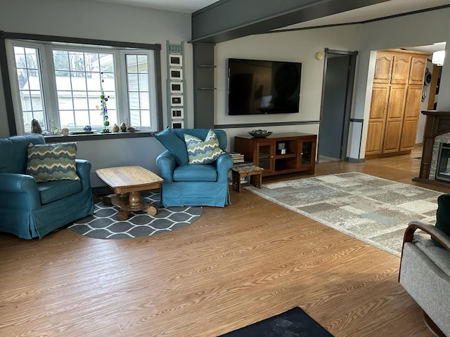 living room featuring light wood-style flooring and a fireplace