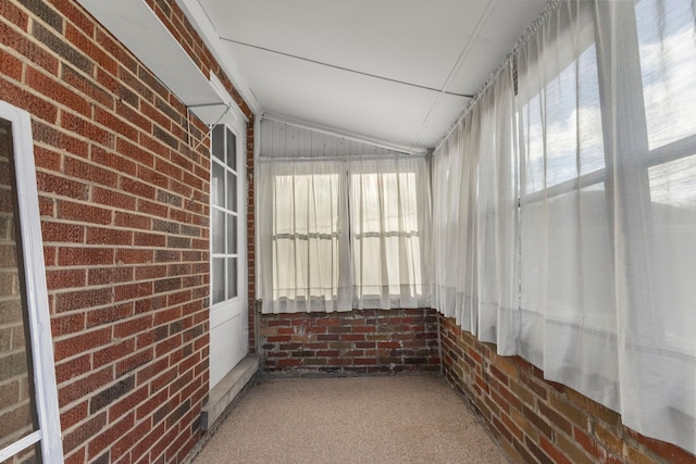 unfurnished sunroom featuring a wealth of natural light and lofted ceiling