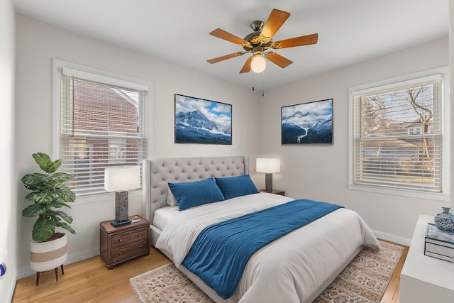 bedroom featuring light wood finished floors, a ceiling fan, and baseboards