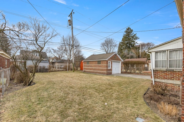 view of yard featuring a garage, driveway, an outdoor structure, and fence