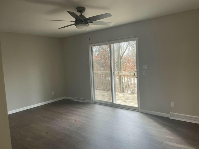 unfurnished room featuring a ceiling fan, visible vents, dark wood finished floors, and baseboards