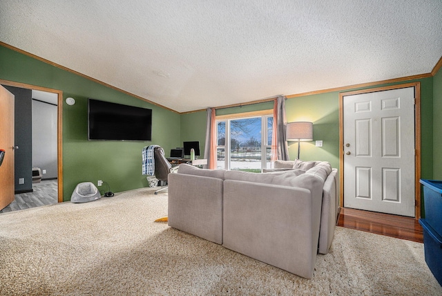 living room featuring lofted ceiling, carpet floors, ornamental molding, and a textured ceiling