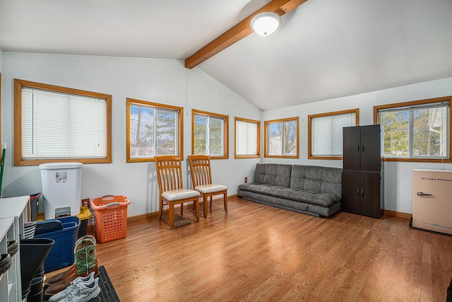 living room with lofted ceiling with beams, light wood-style flooring, and baseboards