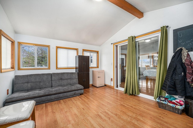 living area with lofted ceiling with beams, light wood finished floors, and baseboards