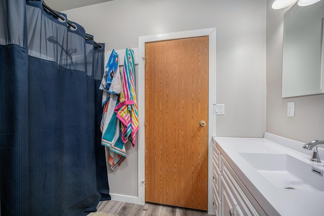 bathroom with curtained shower, vanity, and wood finished floors