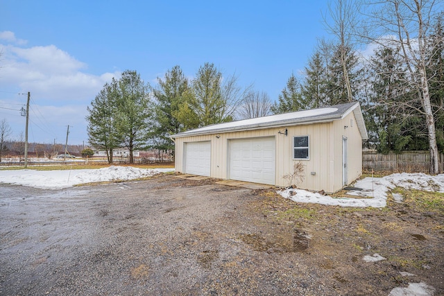 detached garage featuring fence