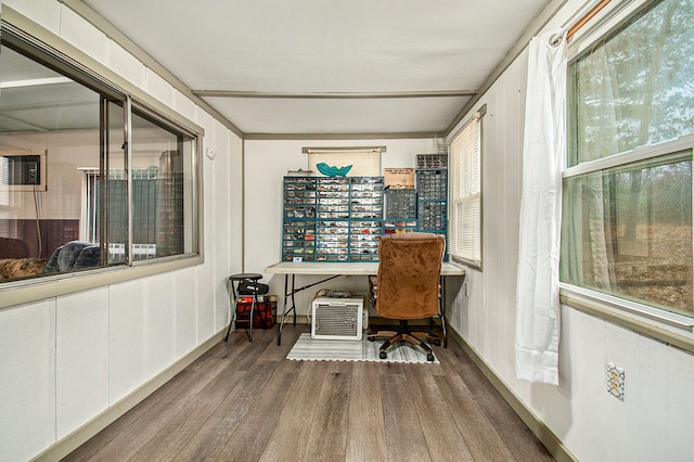 office space with plenty of natural light, built in desk, and wood finished floors