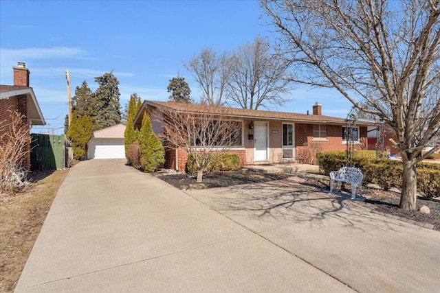 single story home featuring an outbuilding, a porch, a chimney, a detached garage, and brick siding