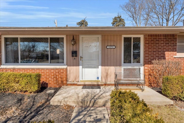 entrance to property with brick siding and covered porch