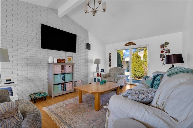 living room featuring beam ceiling, a notable chandelier, high vaulted ceiling, wood finished floors, and brick wall