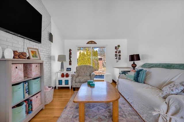 living area featuring vaulted ceiling and wood finished floors