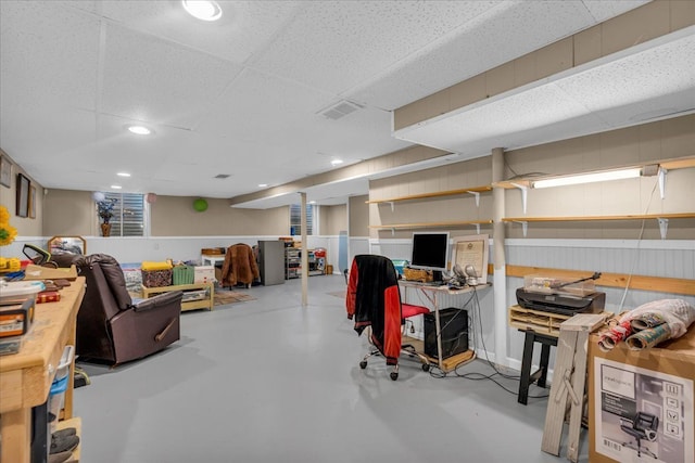 finished basement featuring visible vents and a drop ceiling