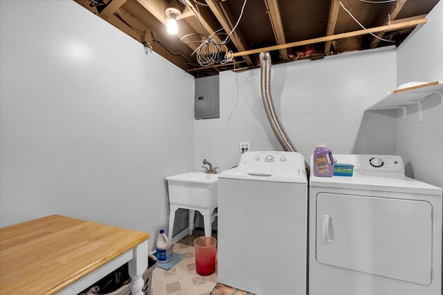 washroom with electric panel, laundry area, washing machine and dryer, and a sink