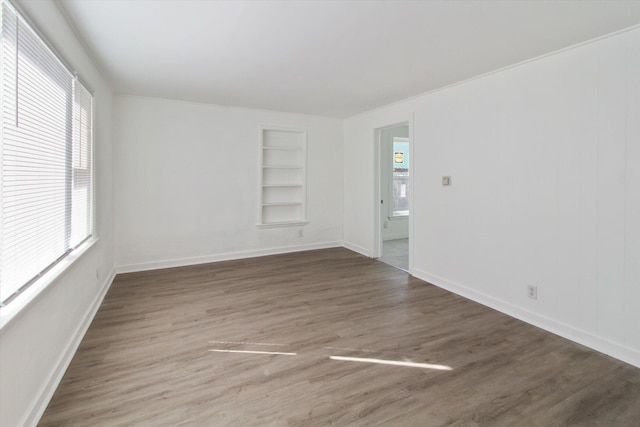 225 E Home St, Edmore, MI 48829 - empty room with built in features, wood finished floors, and baseboards