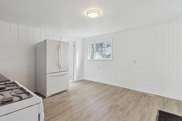225 E Home St, Edmore, MI 48829 - kitchen featuring white appliances, light wood-type flooring, and baseboards