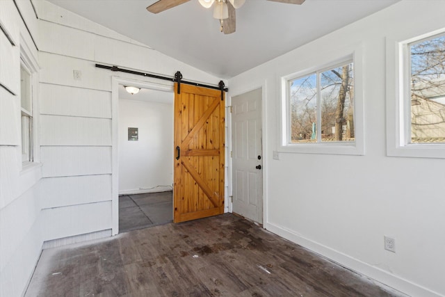 225 E Home St, Edmore, MI 48829 - spare room featuring a barn door, vaulted ceiling, ceiling fan, plenty of natural light, and dark wood-style floors