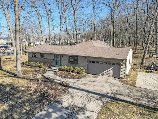 ranch-style home with a garage, driveway, a shingled roof, and fence