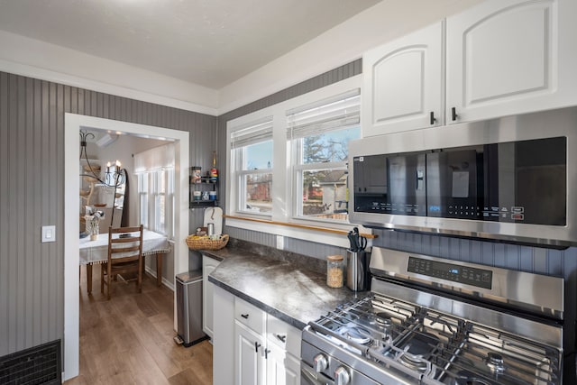 kitchen with dark countertops, visible vents, stainless steel appliances, and white cabinets