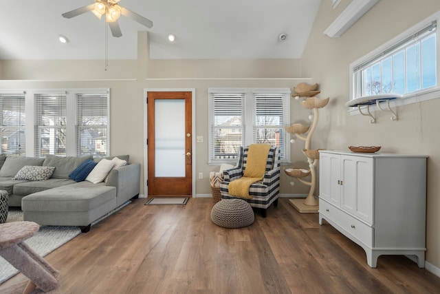 living area featuring lofted ceiling, plenty of natural light, wood finished floors, and baseboards