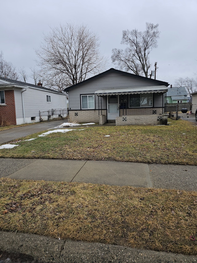 bungalow-style house with fence and a front yard