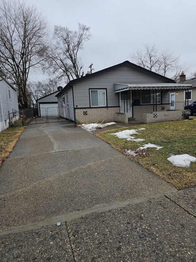 view of front of property featuring an outbuilding, brick siding, and fence