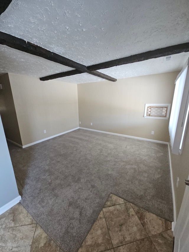 unfurnished living room featuring carpet floors, beamed ceiling, and a textured ceiling